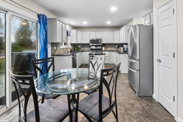 kitchen with tasteful backsplash, sink, white cabinets, and stainless steel appliances