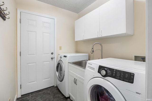 clothes washing area featuring cabinets, dark tile patterned flooring, sink, separate washer and dryer, and a textured ceiling