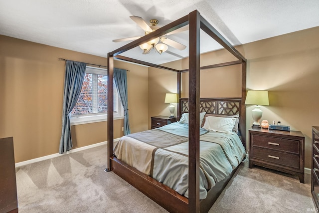 bedroom featuring ceiling fan, light colored carpet, and a textured ceiling