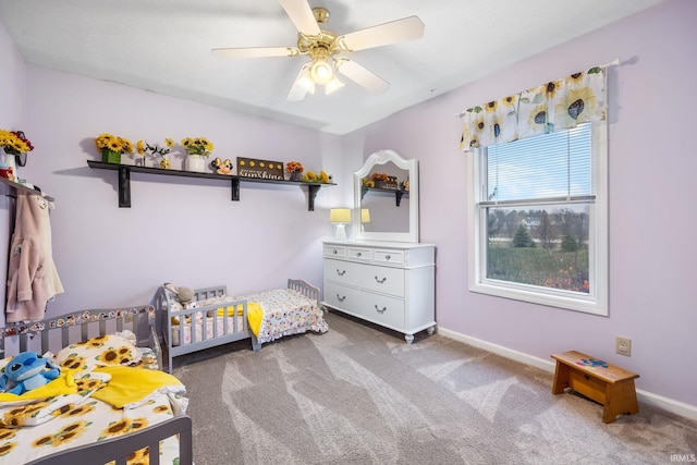 bedroom featuring carpet flooring, ceiling fan, and a crib