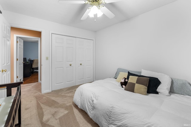 carpeted bedroom with ceiling fan and a closet