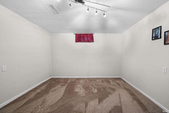 carpeted spare room featuring rail lighting