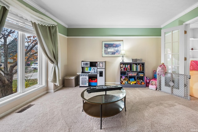 playroom with carpet floors, a wealth of natural light, and crown molding