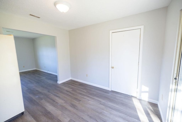 empty room featuring a textured ceiling and hardwood / wood-style flooring