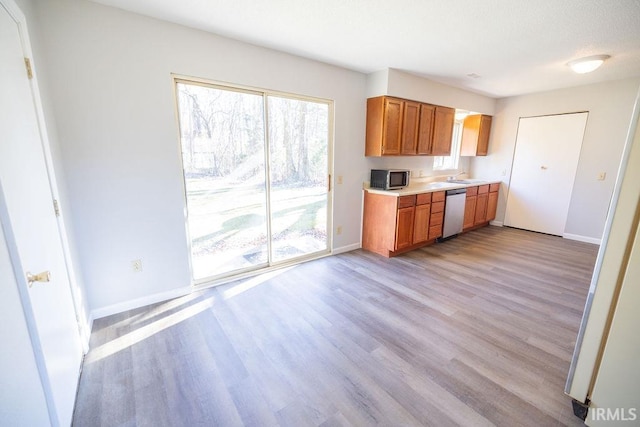 kitchen with sink, appliances with stainless steel finishes, and light hardwood / wood-style flooring