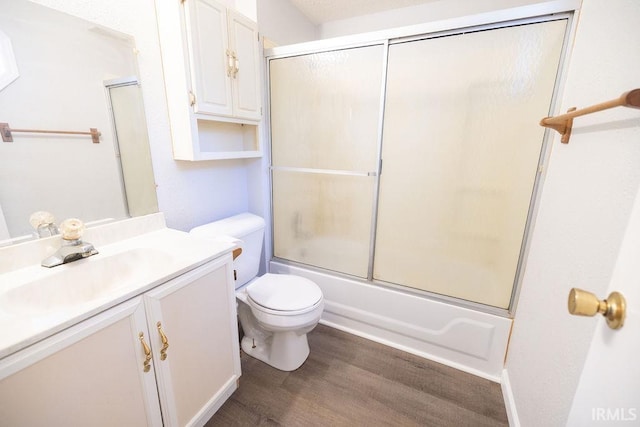 full bathroom featuring hardwood / wood-style flooring, vanity, toilet, and enclosed tub / shower combo