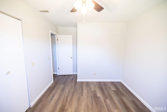 unfurnished bedroom featuring a closet, ceiling fan, and dark hardwood / wood-style flooring