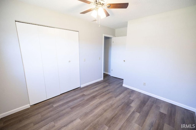 unfurnished bedroom with ceiling fan, a closet, and wood-type flooring