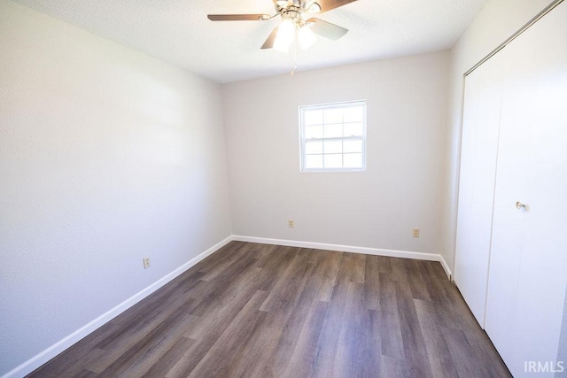 unfurnished bedroom featuring dark hardwood / wood-style floors, ceiling fan, and a closet