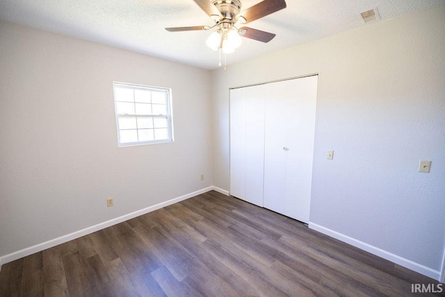 unfurnished bedroom featuring a closet, ceiling fan, and dark hardwood / wood-style flooring