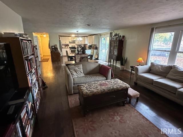 living room featuring a chandelier, a textured ceiling, and hardwood / wood-style flooring