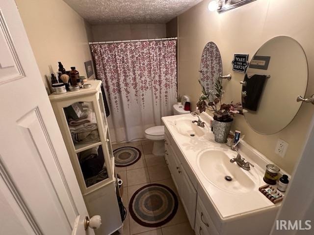 bathroom featuring vanity, a textured ceiling, tile patterned floors, and toilet