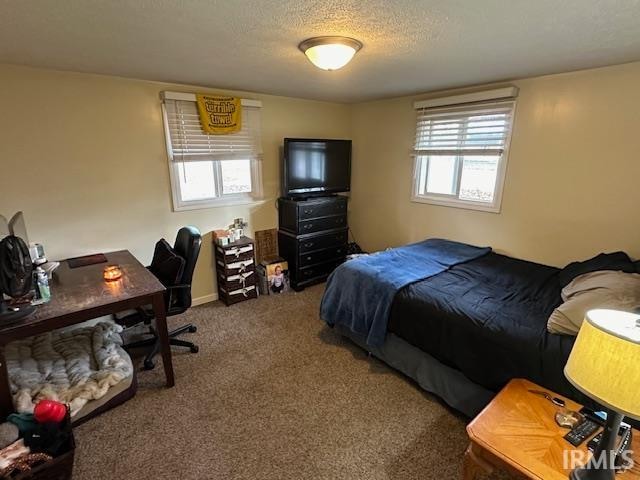 bedroom featuring a textured ceiling and dark colored carpet