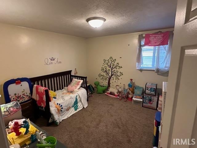 bedroom with carpet, a textured ceiling, and a crib