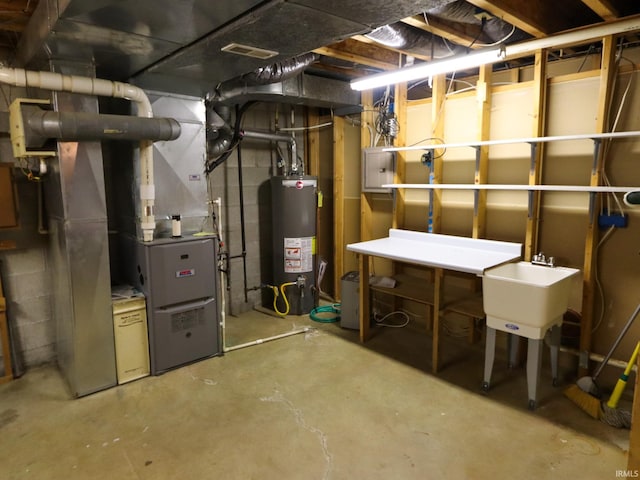 utilities featuring heating unit, sink, gas water heater, and electric panel