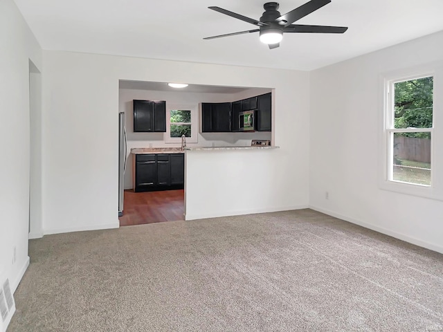 kitchen featuring ceiling fan, dark carpet, sink, and stainless steel appliances