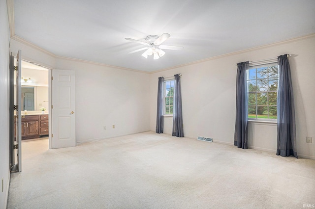 empty room featuring crown molding, ceiling fan, and light colored carpet