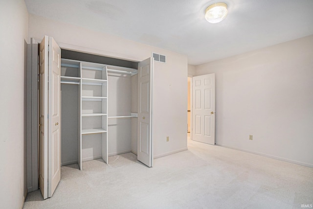 unfurnished bedroom featuring light carpet and a closet