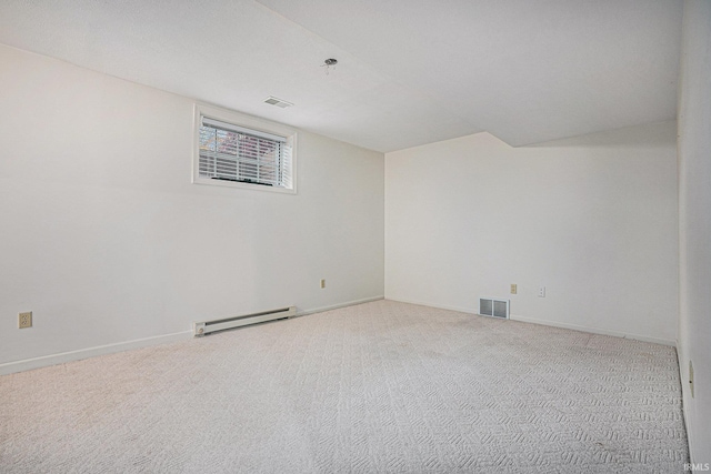 carpeted spare room with a baseboard heating unit