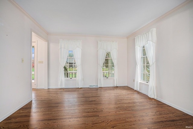 empty room with plenty of natural light, dark wood-type flooring, and ornamental molding