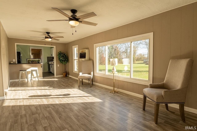 sitting room featuring ceiling fan, wood-type flooring, a textured ceiling, and heating unit