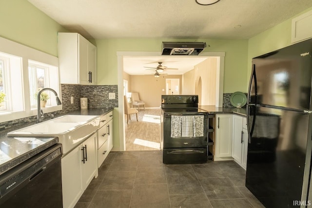 kitchen featuring white cabinets, sink, dark tile patterned floors, and black appliances