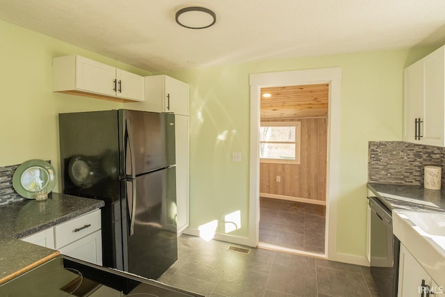 kitchen featuring white cabinets, decorative backsplash, refrigerator, and wood walls