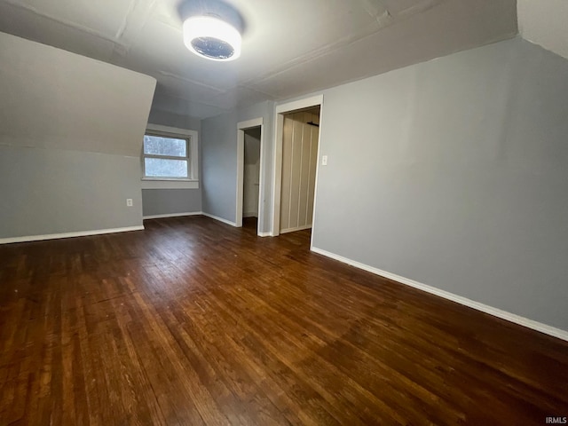 additional living space with dark hardwood / wood-style flooring and lofted ceiling