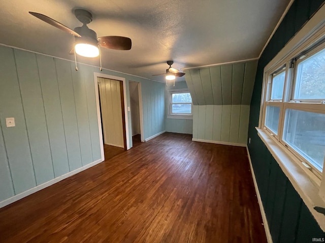 additional living space with dark hardwood / wood-style flooring and a textured ceiling