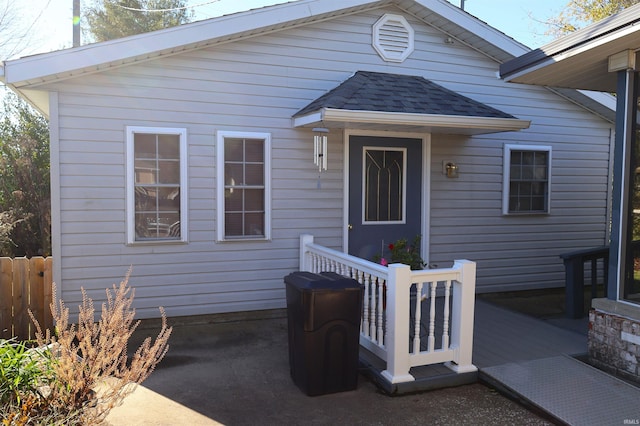 208 Sycamore St, Loogootee, IN 47553 - entrance to property featuring a shingled roof and a wooden deck
