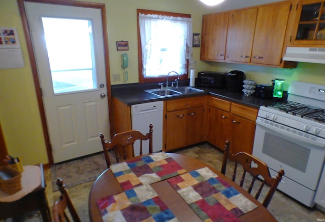 208 Sycamore St, Loogootee, IN 47553 - kitchen featuring white appliances, under cabinet range hood, a sink, dark countertops, and brown cabinets