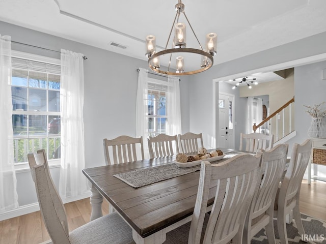 dining area with a chandelier, a healthy amount of sunlight, and light wood-type flooring