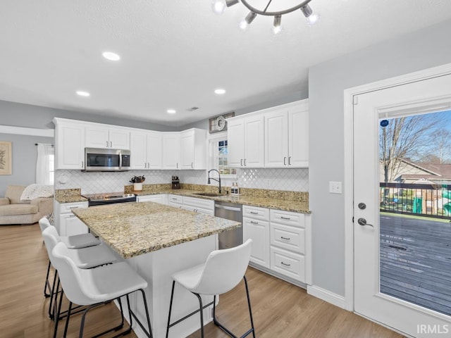 kitchen with white cabinetry, a healthy amount of sunlight, sink, and stainless steel appliances