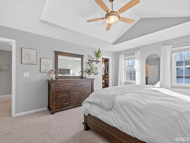 bedroom featuring vaulted ceiling, a spacious closet, multiple windows, and ceiling fan