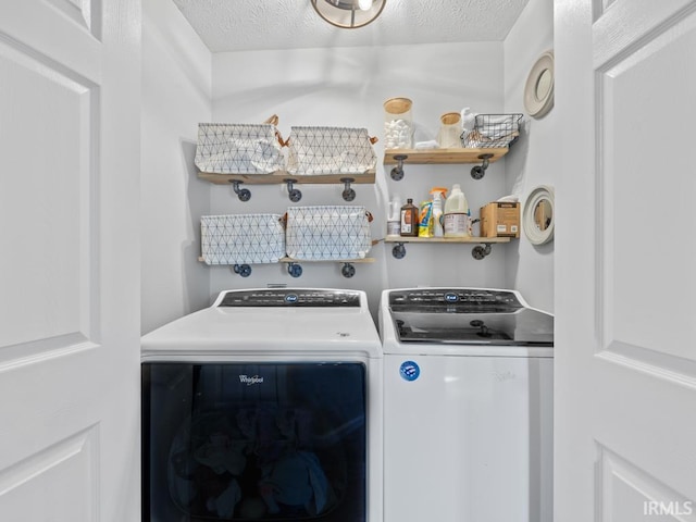 clothes washing area featuring washer and dryer and a textured ceiling