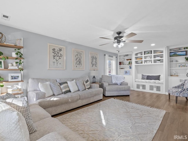 living room featuring hardwood / wood-style floors and ceiling fan