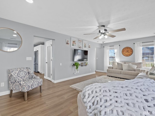 bedroom featuring ceiling fan, stainless steel fridge, and wood-type flooring