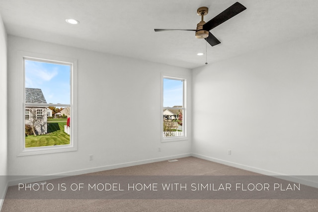 empty room featuring ceiling fan, carpet floors, and a healthy amount of sunlight