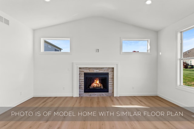 unfurnished living room with hardwood / wood-style floors, a healthy amount of sunlight, and a fireplace