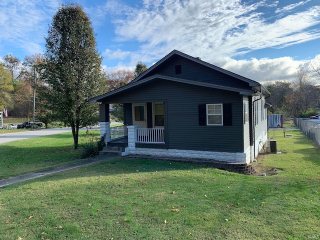 bungalow-style house featuring covered porch, a front lawn, and cooling unit