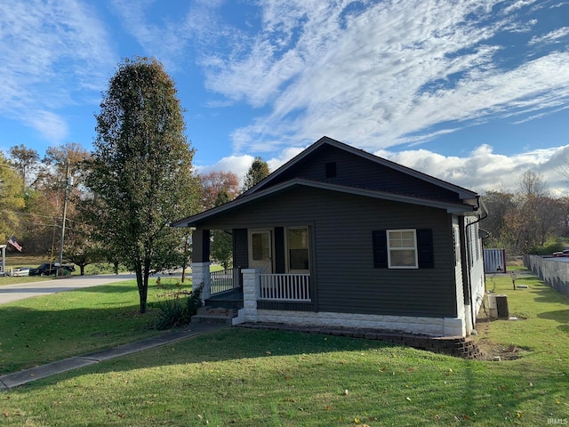 view of side of home with a yard and a porch