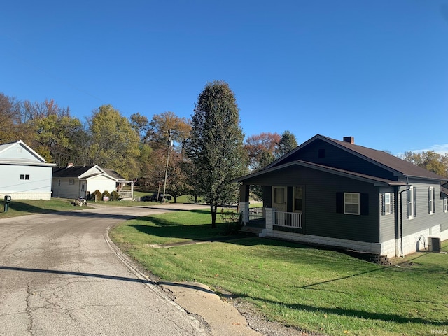 view of side of property with a porch and a yard