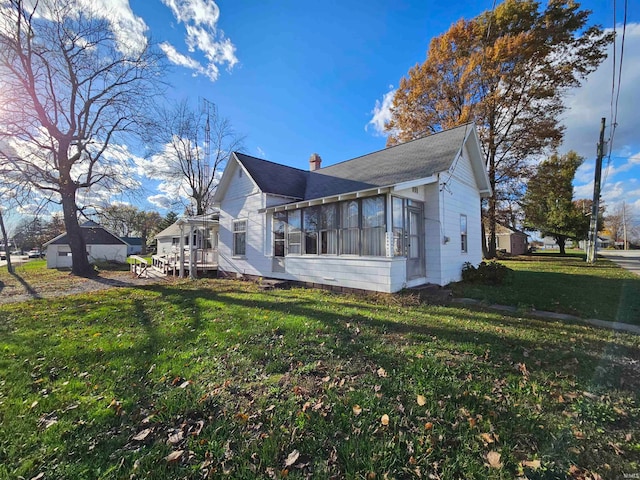 view of side of home with a yard and a sunroom