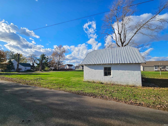 view of side of property with a lawn and an outdoor structure