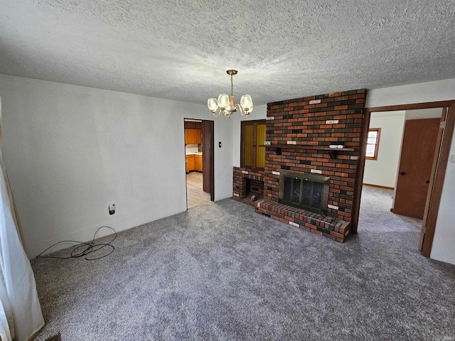 unfurnished living room with a fireplace, a textured ceiling, carpet floors, and a notable chandelier