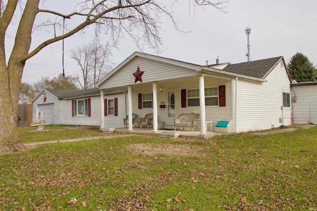 view of front of property featuring covered porch, a garage, and a front lawn