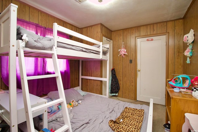 bedroom featuring carpet floors and wood walls