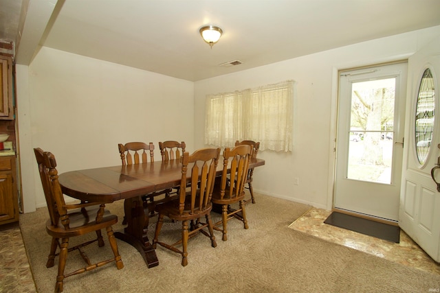 dining area featuring light carpet