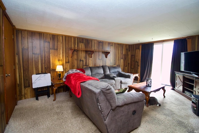 carpeted living room featuring wood walls