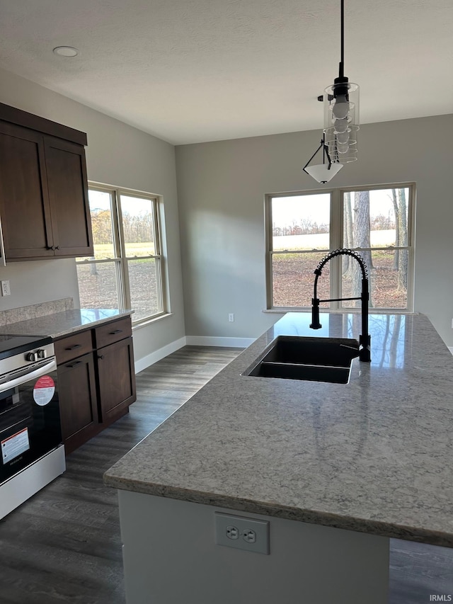 kitchen featuring stainless steel electric stove, dark hardwood / wood-style floors, sink, and a wealth of natural light